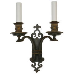 An antique double-light sconce in a darkened finish