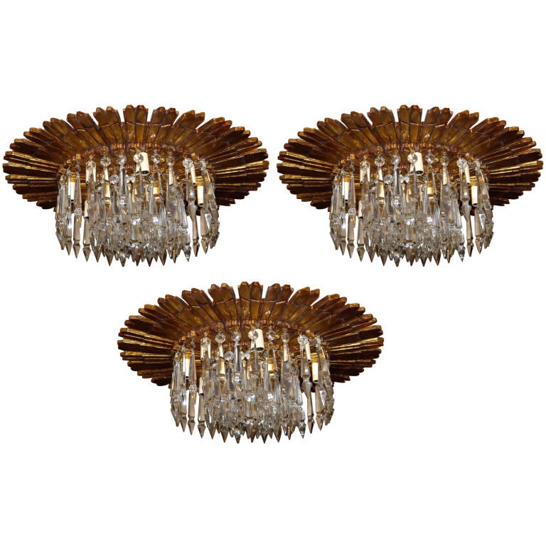 A pair of 1940's Italian carved wood sunburst shaped light fixture with crystal drops, original gilt finish, patina and eight lights. Sold individually.

Measurements:
Height: 9.5