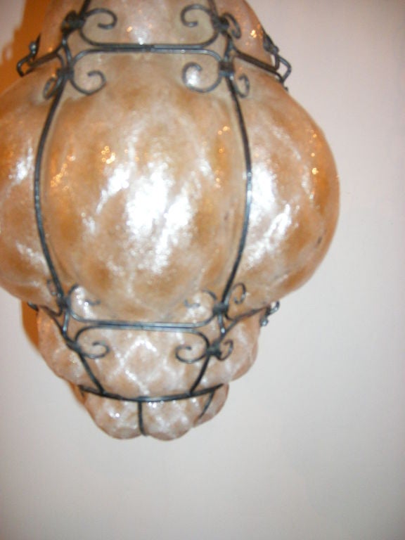 A circa 1950's Italian blown amber glass lantern with an iron frame and single interior light.

Measurements:
Height: 14