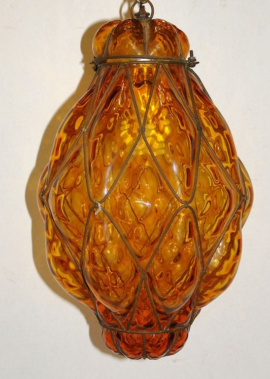 A circa 1950s hand blown amber glass and iron lantern with interior light.

Measurements:
Height 17