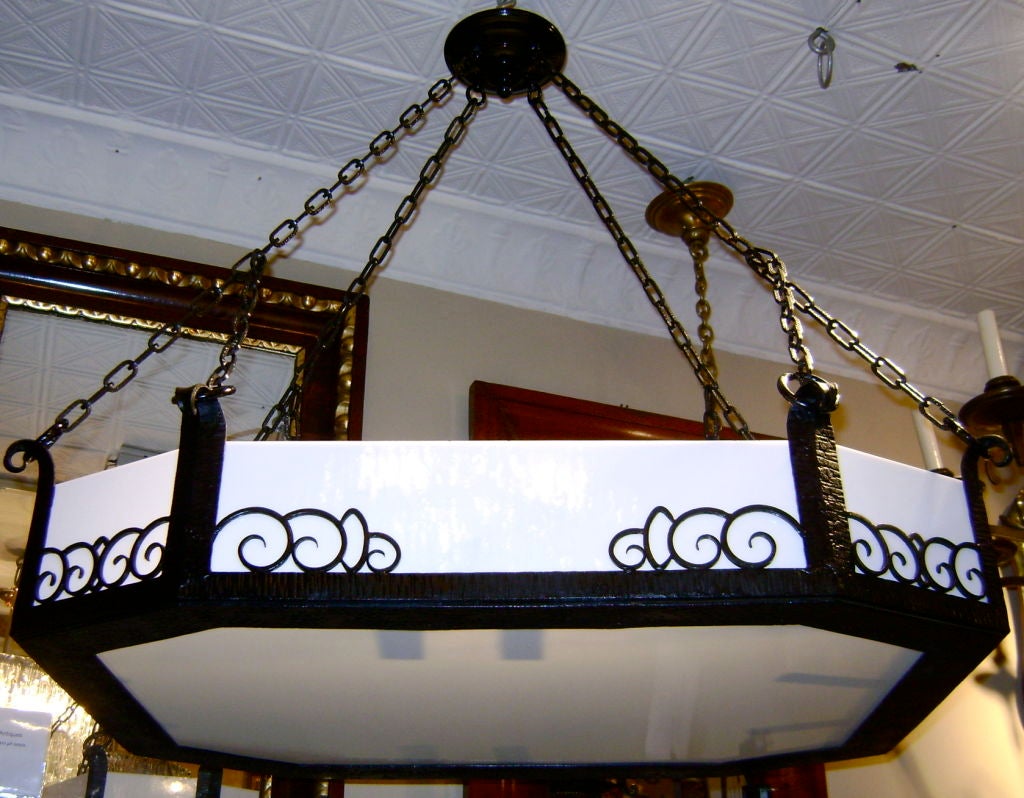 A horizontal wrought iron chandelier with scrolling motif on body. Inset leaded glass, eight interior lights.
Measures: 29