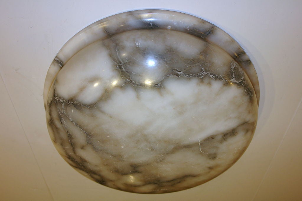 Luminaire italien en albâtre sculpté avec des veines grises, datant de 1920. A équiper d'une chaîne en bronze et d'un baldaquin.

Mesures
Hauteur : 4 3/4″.
Diamètre : 17 1/2″.

 