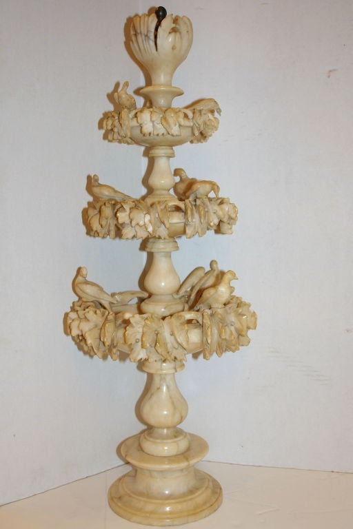 A circa 1920  Italian carved alabaster fountain shaped sculpture with birds and leaves on body.
Measurements:
Height: 29.5