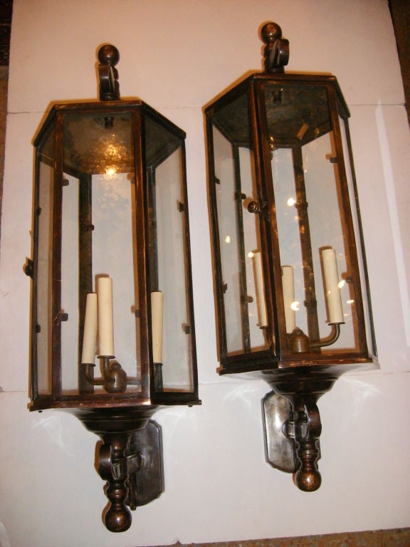 Pair of large patinated bronze wall mounted lanterns with interior light cluster and clear glass pannels.
34