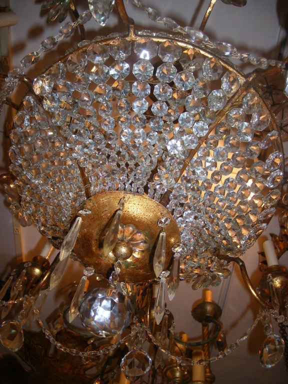 A French circa 1940’s gilt metal basket shaped eight-light chandelier with original gilt finish, with crystal body, pendants and flowers.

Measurements:
Drop: 33″
Diameter: 30″


