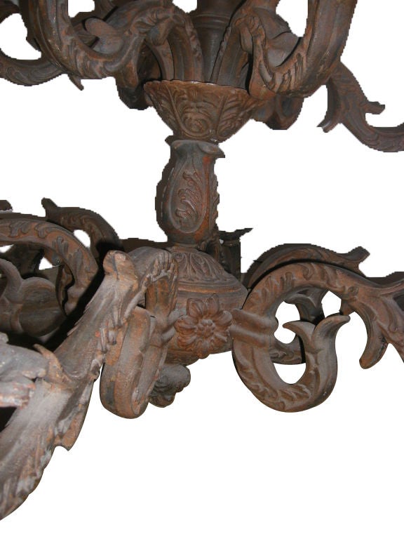 A French cast-iron two-tier iron chandelier with foliage motif on body and arms, floral decoration between the arms, original canopy and patina, circa 1900.

Measurements:
Minimum drop 48