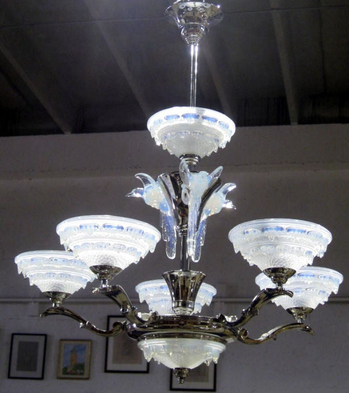 An amazing and spectacular 1930’s French Art Deco chandelier!  With its nickel shaft, cones, wings and rings supporting seven illuminated opalescent glass bowls dripping icicles and three illuminated opalescent glass birds in flight, this fixture