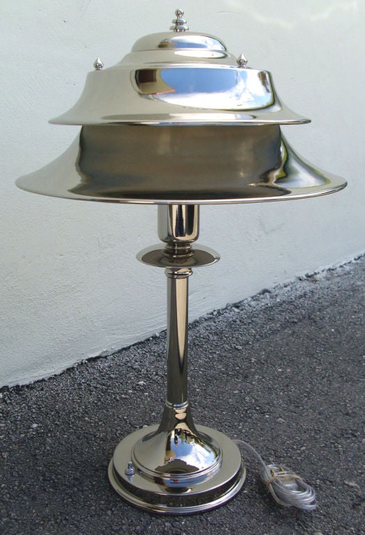 This large American art deco table lamp was made by the Markel Company of Buffalo, New York in the 1930’s.  The lamp, in brilliant nickel, has a stepped base, speed disks in the central shaft and a double shade with the distinct Markel finial on