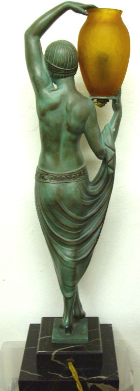 This French art deco illuminated metal statue was sculpted by Pierre Le Faguays (1892 – 1935) and cast by the LeVerre foundry in the 1920’s.  The statue, named “Odalisque” depicts a young woman nude to the waist holding an orange craqueleure glass