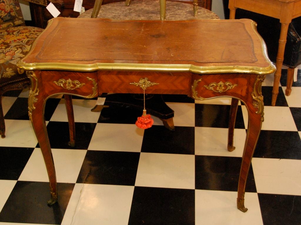 Louis XV style bureau plat with tooled leather writing surface and three short drawers on cabriole legs