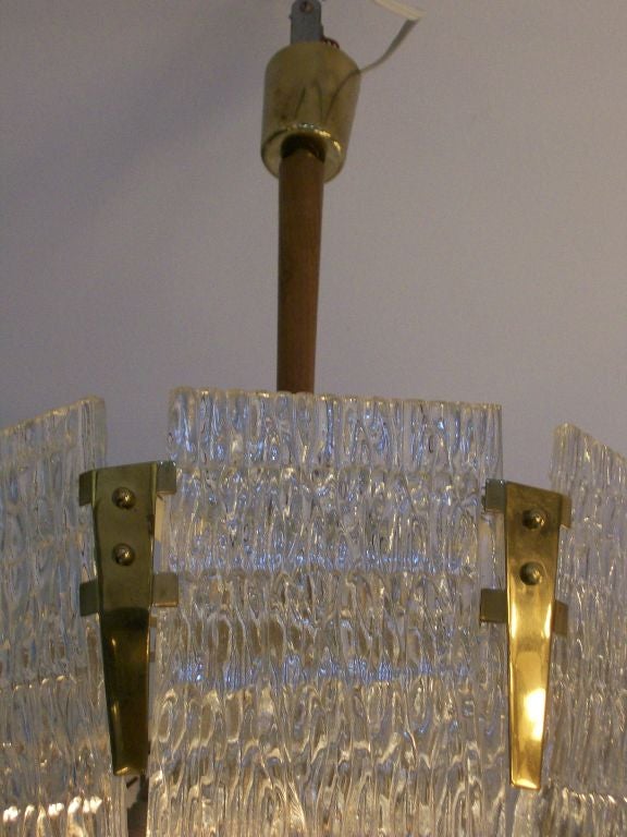 An 8 paneled Orrefors glass chandelier with brass fittings and rosewood stem.