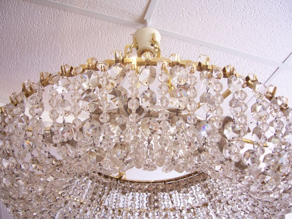This sixteen light chandelier draped with rows and rows of vintage Austrian cut crystals in ring design is amazing. Fully restored and rewired to US standards.