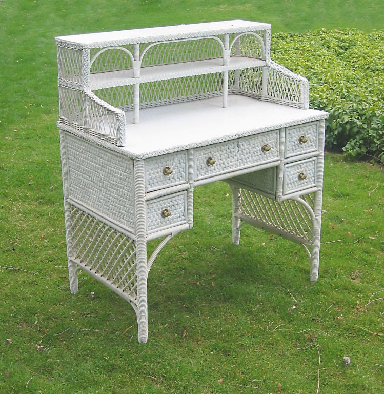 Bar Harbor style wicker desk in old white paint.  Two-level wicker gallery with latticed reeding on back & sides; painted oak surfaces with braided borders; substantial writing area.  Case component with solid basket woven caning & full lower side