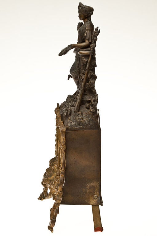 French Spelter and Gilt Bronze Mantle Clock, Late 19th Century, the enamel dial with two train movement surmounted by a classical figure of a woman leaning on a column, the base with agate panels raised on c-scroll form feet.