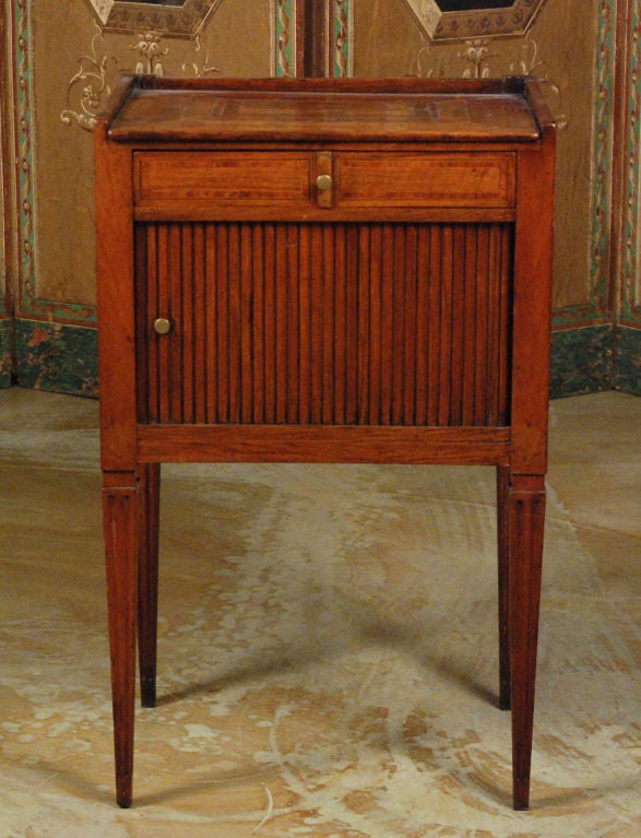 The rectangular top with inlays over a case with a single drawer and a tambour door all resting on four tapering legs.