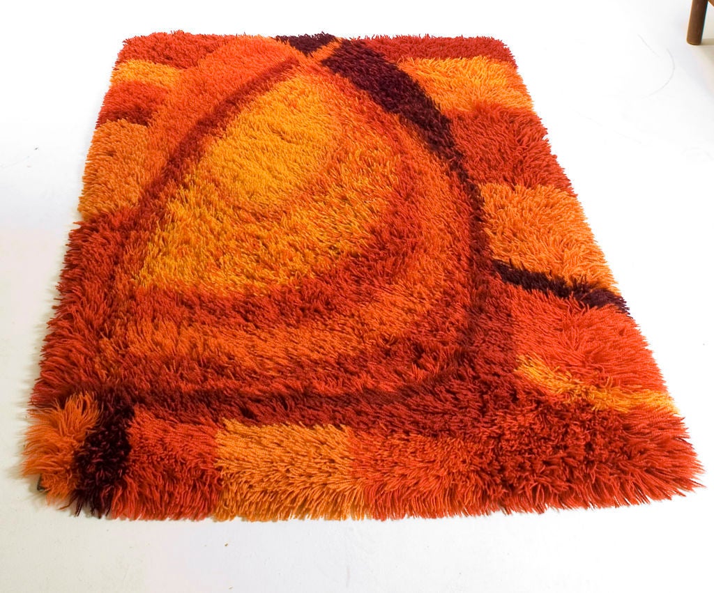 This lush wool Rya rug features an abstract oval pattern in burnt orange, rust and chocolate.