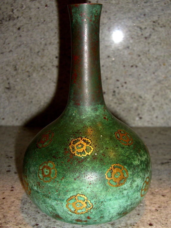 A beautifully patinated vase with inlaid floral designs by the reknown French firm Christofle. It dates to the beginning of the 20th century. It is stamped on the base with the company's name and logo. There is verdigris patina loss to the neck and