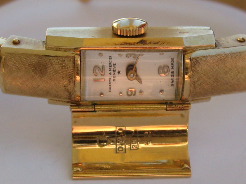 This is a gorgeous vintage ladies Baume & Mercier bangle bracelet watch. This lovely timepiece is solid 18K gold. The bracelet has a spring loaded action for adjustable fitting and a safety clasp. It has a manual winding movement and is in good