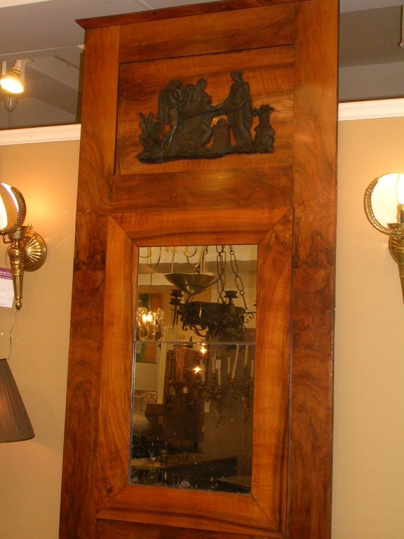 A early to mid-19th century Northern European walnut pier mirror of rectangular form with a recessed ebonized frieze of applied neoclassical figures with a two plate mirror, the top replaced, the bottom original.



 