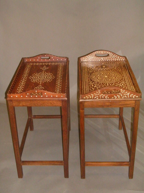 A campanion pair of early 20th century ivory inlaid rosewood removable trays on later custom rosewood stands, each with pierced handles, a central inlaid medallion, one bordered with a band of inlay, the other with allover design, the outside