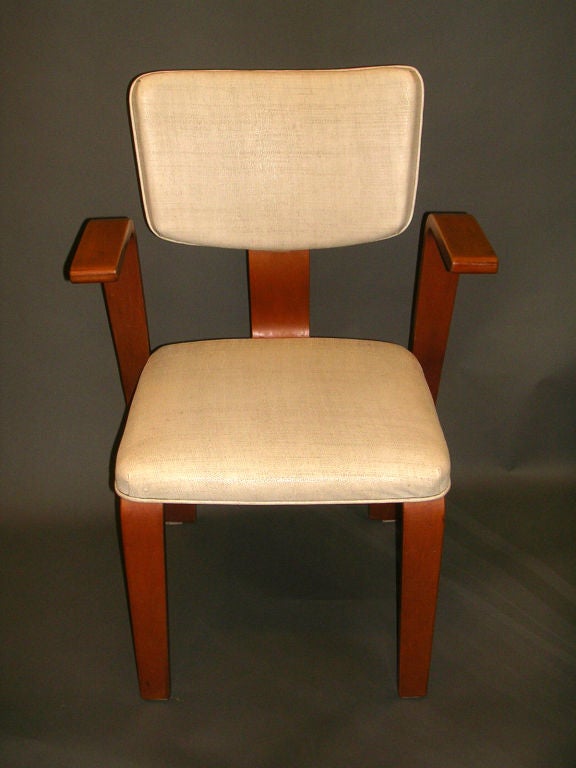 A set of four mid-century honey-colored bentwood Thonet chairs upholstered in original linen textured off-white faux leather, the upholstered back with nailheads on reverse supported by a curved splat, the upholstered seat resting on four sided