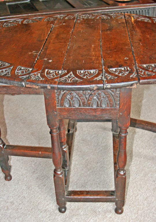 Characterful English oak Jacobean style oval wine table.  This table has several obvious repairs which, in our opinion adds to it's great age.   It is likely to be late 18th century or early 19th.   The oak patina is DRAMATIC.   The top is