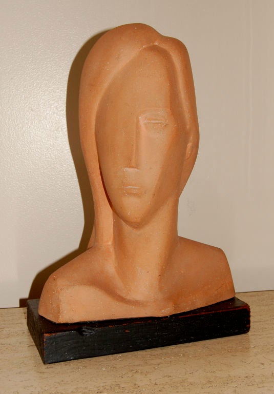 Figurative abstract bust of a woman rendered in terra cotta. Wonderful delicate lines along with a great color and texture from the terra cotta medium. Resting on a painted wood base and signed Coulter on the back of the piece.