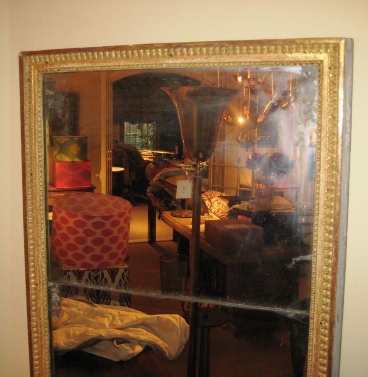 A French Louis XVI mirror with original gilwood frame and retaining its original 2-part mercury glass plate.