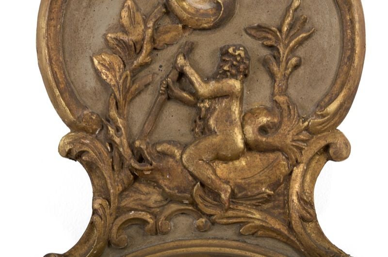 The scrolled and rocaille carved case with a thermometer above a circular barometer dial painted with Adam and Eve, the dial inscribed 