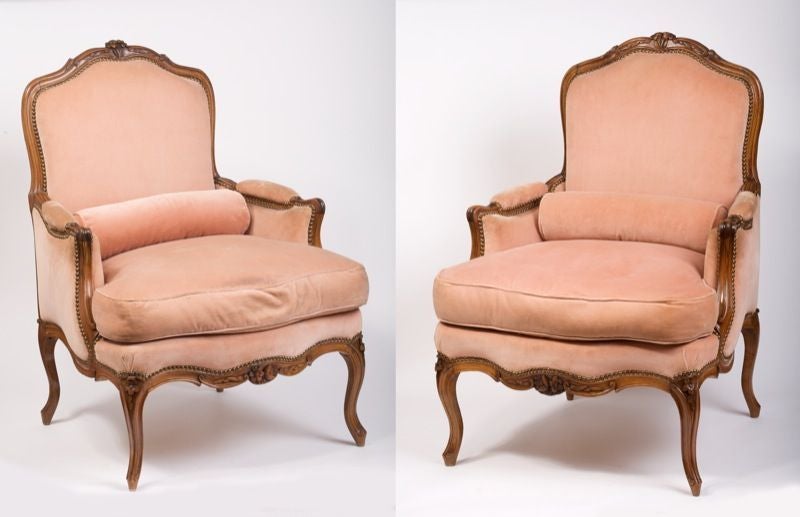 Each with arched rectangular back, padded arms and seat with cushion covered in velvet, the arched top rail and seat-rail centered by a floral spray, raised on floral-headed cabriole legs.