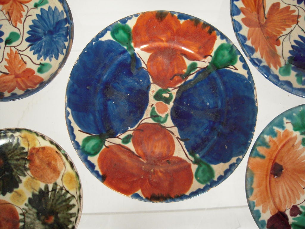 Collection of 5 vintage, brightly colored Mexican pottery plates from Oaxaca, southern Mexico, each decorated with characteristic floral design.