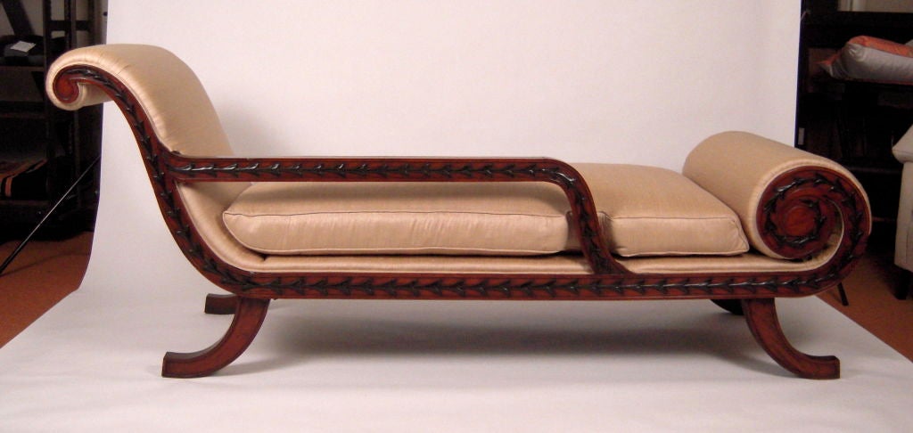 A fine neoclassical recamier, made in Colonial India for the English market, in teak carved with ebonized bellflower decoration along the rails (both sides) with scrolled foot rest, newly upholstered in heavy weight silk with loose down cushion and