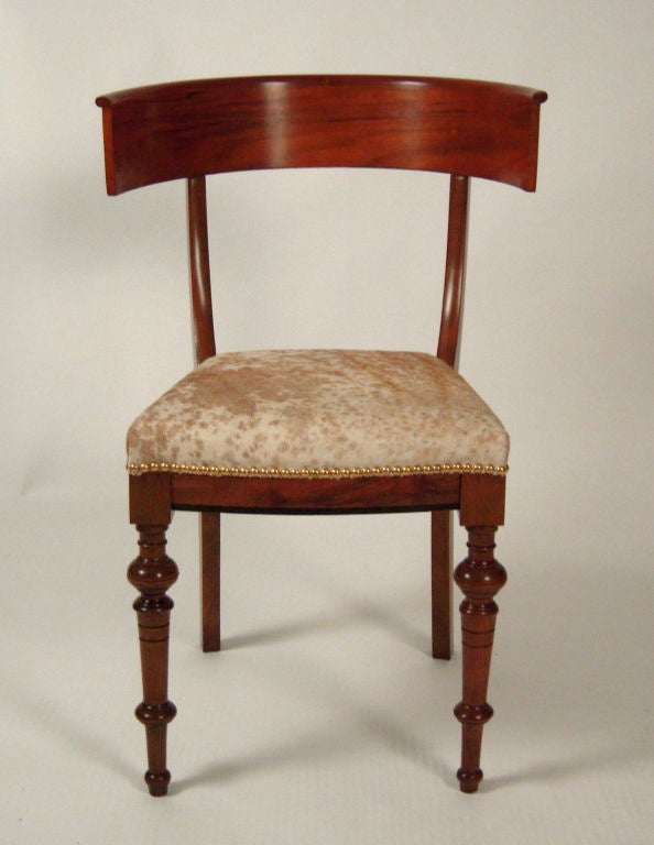 A fine, very sculptural (and comfortable) Danish Biedermeier period klismos chair in walnut and birch with semicircular curved back and incised turned legs, the seat upholstered in tan and white pony with brass studs. Excellent as desk chair or as