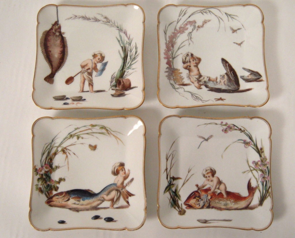 An unusually themed set of  8 fine quality porcelain dishes by Haviland Limoges, of bracketed square form, with gilded edges, each decorated with a playful little chef/cherub preparing seafood. 2 of the designs repeat 3 times, with 4 different
