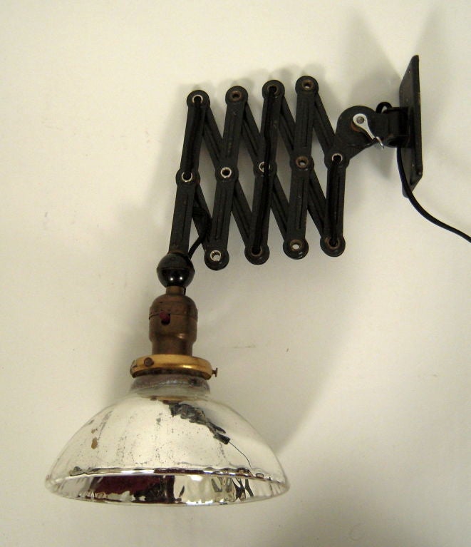 A metal wall mounted industrial light, with adjustable folding accordion metal arm with locking mechanism and mercury glass shade. Newly re-wired.