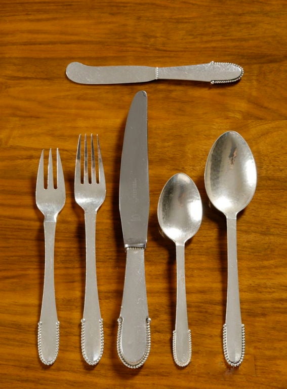 A nearly complete Georg Jensen silver flatware service for 12 in the Beaded pattern, 69 pieces, each place setting with 6 pieces, comprising 12 Dinner Forks, 12 Salad Forks, 12 Dinner Knives, 12 Soup Spoons, 12 Butter Knives, 9  Teaspoons.<br