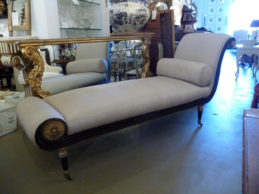 A superb English Regency period paint and gilt daybed retaining its original surface and casters. Upholstered in a grey silk.