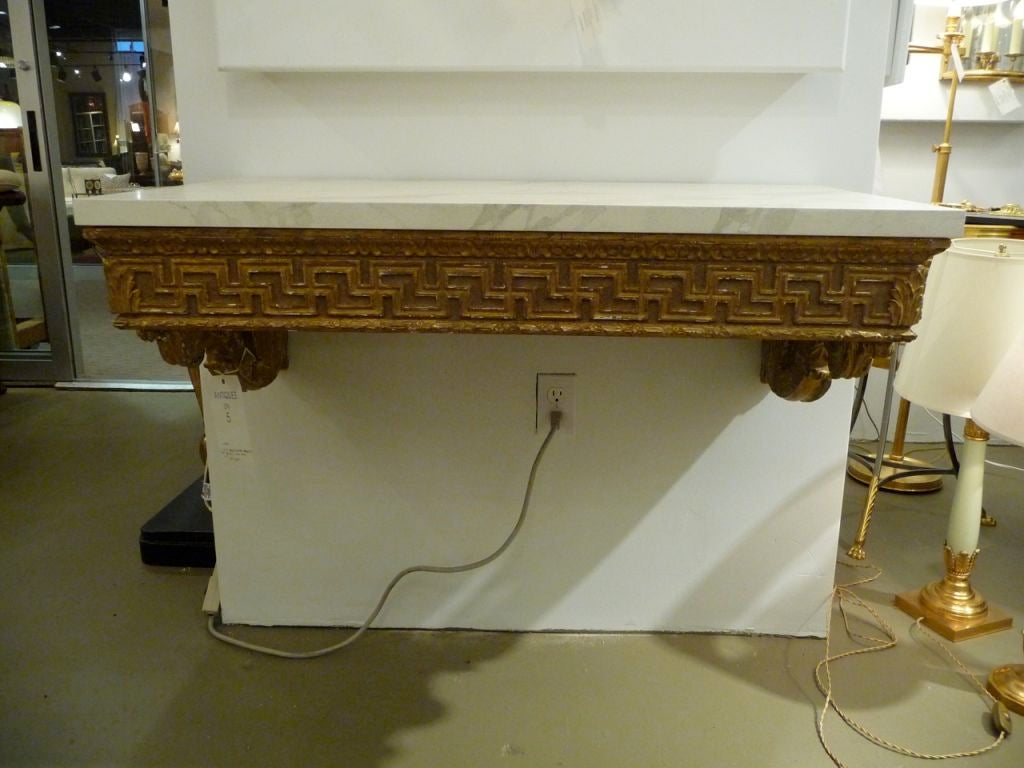 A French giltwood wall mount console with marbleized top and greek key border. Original gilding, New top.