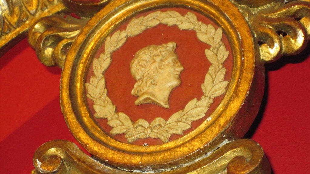 Arched chest with central medallion, over a mirror plate with applied empire motifs.