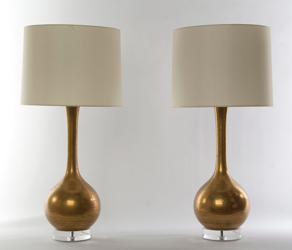 SOLD AS PAIR / $2,500<br />
+ A gorgeous pair and sleek ceramic lamps<br />
+ Classic single gourd profile<br />
+ Long, slim neck flares slightly at top<br />
+ Beautiful glaze is a matte, burnished gold with an allover crackle<br />
+ Subtle