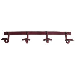 Stitched burgundy leather coat hooks by Jacques Adnet