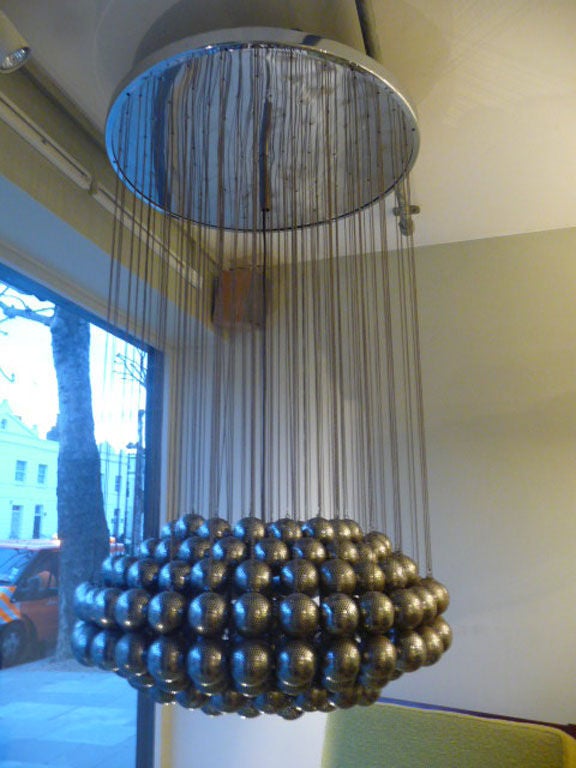 suspension ceiling fixture with pierced steel spheres hanging from individual chains.