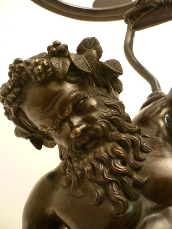 Patinated Bronze statue of Silenus with a serpent, after the original discovered in Pompeii in 1863. Italian c.1870<br />
<br />
In Greek mythology, Silenus was a companion and tutor to the wine god Dionysus. <br />
<br />
Modeled as an oil lamp