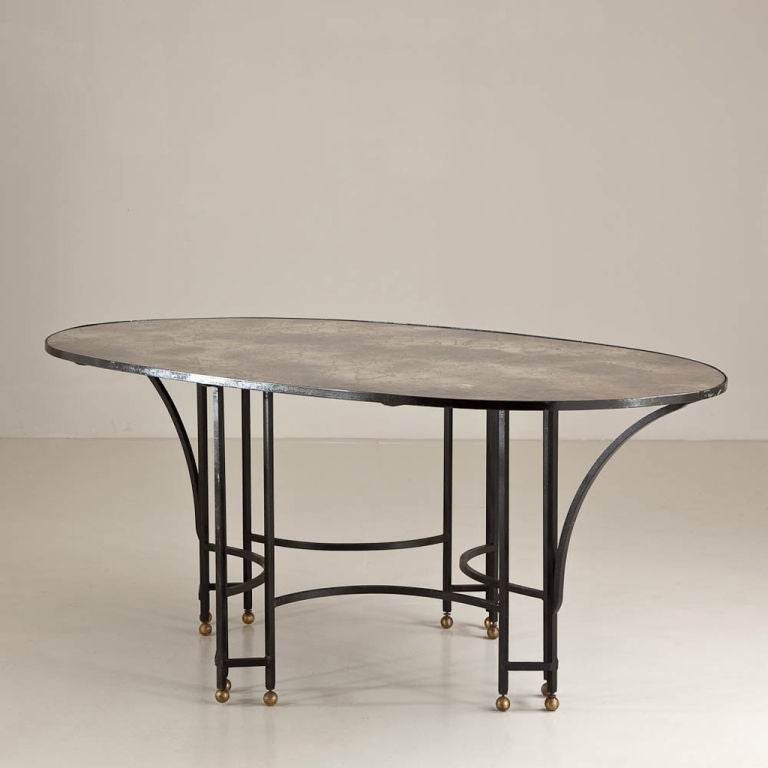 A 1950s Wrought Iron Oval Table with Brass Ball Detailing and Elegant Reverse Painted Glass Top in Grey and Gold Veined Tones 