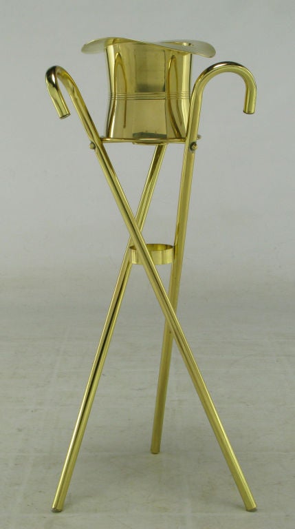 Unique and inspired champagne cooler or ice bucket on three canes in tripodal form stand. Solid brass top hat and brass plated canes.