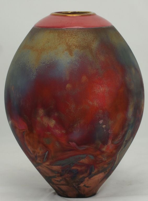 Excellent in color and intensity, this Japanese raku fired vase is traditionally tear drop shaped with a glazed magenta and gilt rim. Signed and dated.