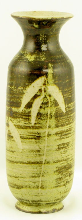 Vase aus brauner und goldener Keramik, spiralförmig glasiert, innen weiß glasiert. Wunderschöne, zarte Blumendetails auf zwei Seiten. Trompetenförmige Öffnung und Sockel mit Fuß.  Signiert 