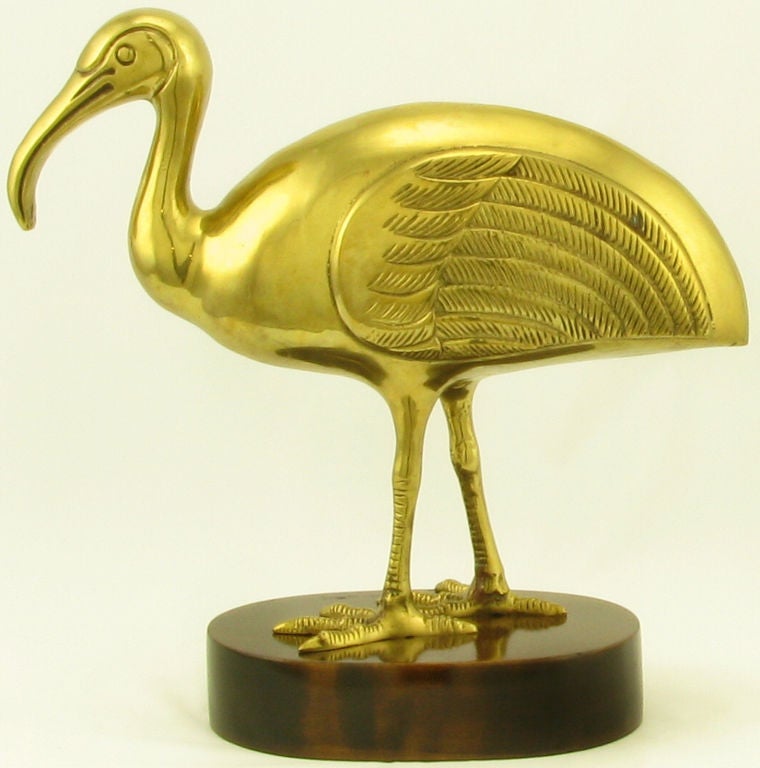 Simply detailed solid brass ibis bird atop an oval walnut plinth base.