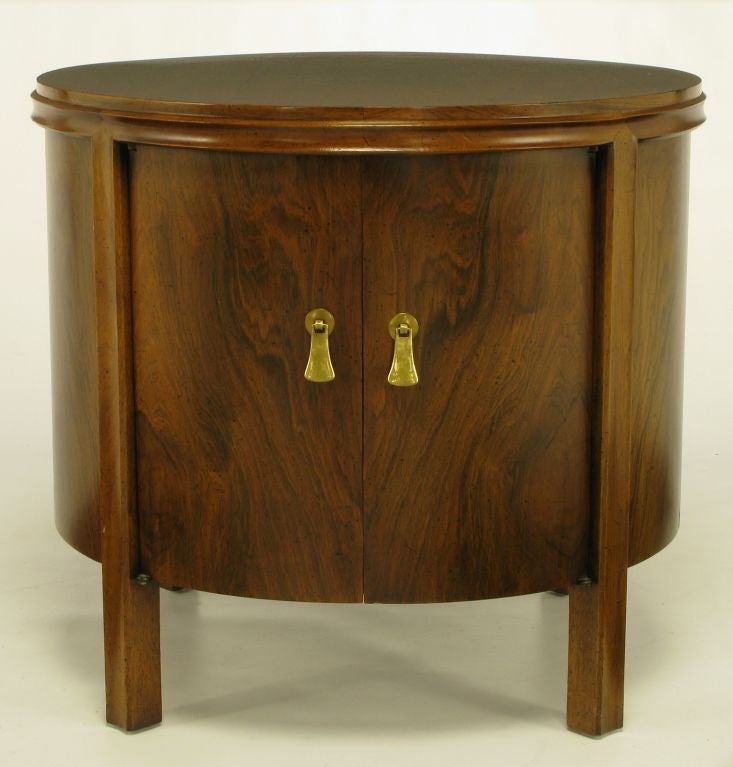These rosewood drum-style tables feature four clean lined legs and a double edge detailed top. Large open center for ample storage and brass drop-tab pulls.  Can be used as nightstands, end tables, or petite cabinets for storage.<br />
<br