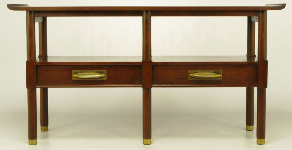 Beautifully designed chinoiserie console table with six legs. Lower shelf features two drawers with brass tray pulls and rectangular brass escutcheons. Tubular walnut legs are finished in brass sabots.  Manufactured by Willett Furniture, a